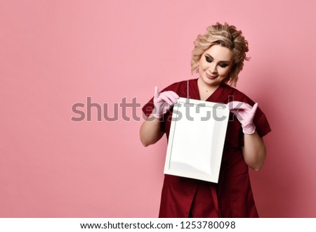 Young excited woman holding empty blank board smiling on pink background