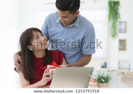 Asian boyfriend giving present box to his girlfriend on for birthday.