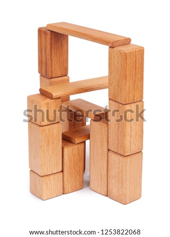 Photo wooden constructor of small cubes, triangles, balls and other forms of beech on a white isolated background. Wooden constructor, folded in the form of a tower