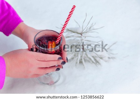 woman holds glass of mulled wine outdoors in winter