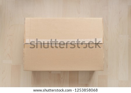 Top view of brown cardboard box on wood background.