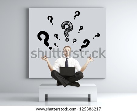 man meditating in the room and poster on wall