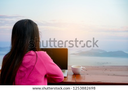 Woman Wearing Pink Sitting on the Terrace with a Computer and a Cup of Coffee on the Side. Local Journalist or Morning Coffee Drinker. Write Articles About Traveling in South Asia. Travel story