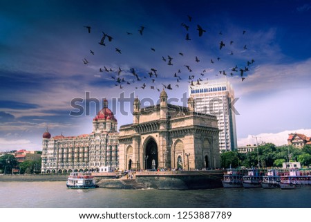 birds fly over gateway of india with blue sky at morning, mumbai, india