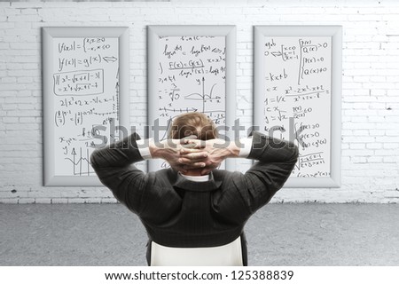 businessman looking formulas on desk