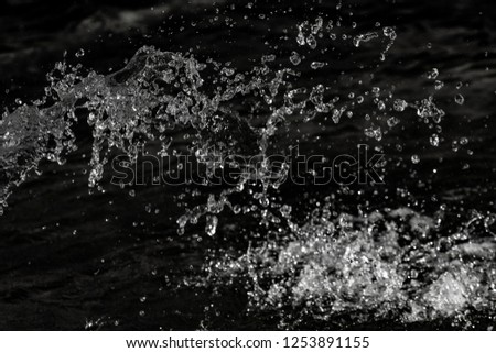 water drops in the air on a dark bokeh background