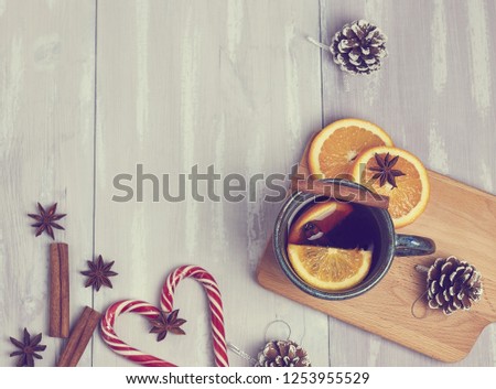 A ceramic cup of warming tea with cinnamon and orange on a rustic white table. copy space. view from above. New Year's composition.