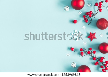 Christmas or winter composition. Frame made of snowflakes, balls and red berries on pastel blue background. Christmas, winter, new year concept. Flat lay, top view, copy space