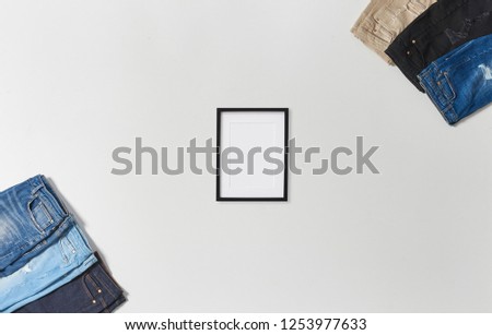 Jeans and frame concept on the white table and white background isolated.