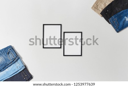 Jeans and frame concept on the white table and white background isolated.