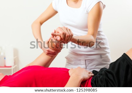 Patient at the physiotherapy doing physical therapy exercises with his therapist Royalty-Free Stock Photo #125398085