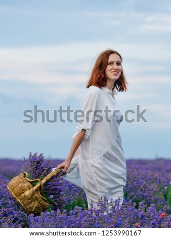 Young girl in white dress, posing in a lavender field.