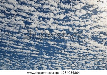 Many small white clouds in the blue sky.