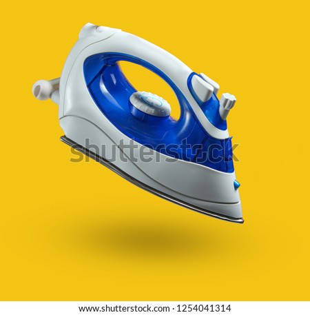 Modern wireless iron for ironing isolated on a yellow background. Levitation, minimalism. Photo with shadow Royalty-Free Stock Photo #1254041314