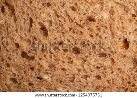 Bread with seeds and raisins as a background. Macro picture