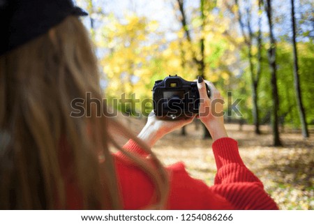 Woman making photos at green park, closeup on camera back screen