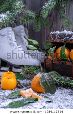 Winter still life with skates and tangerines.