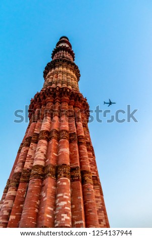A plane flying past the Qutub Minar, Delhi, India