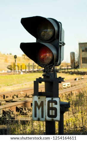 Traffic light shows red signal on modern cargo railway. Red light