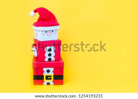 Christmas gift boxes tower in the shape of a Santa Clause on bright yellow background isolated. Xmas. family holiday concept. Merry Christmas and Happy Holidays. Selective focus. Copy space