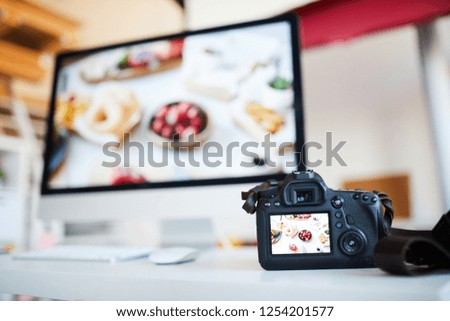 Background image of photo camera with photo of food on table against computer with editing software, copy space