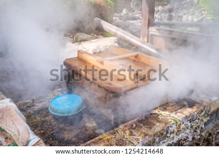 Hot pot steamer near UMI JIGOKU (Sea Hell) pond in autumn, which is one of the famous natural hot springs viewpoint, the japanese in picture means "It's high temper and danger, please don't touch."