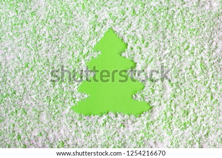 Winter composition with Christmas tree on a green background with artificial snow, flat lay. Greeting card for New Year with copy space.
