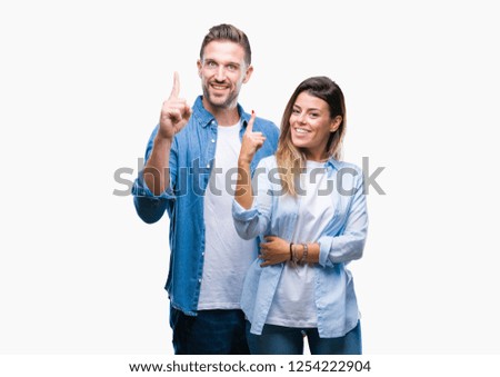 Young couple in love over isolated background pointing finger up with successful idea. Exited and happy. Number one.