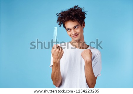 Curly guy looks at the comb               