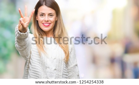 Young beautiful woman casual white sweater over isolated background showing and pointing up with fingers number three while smiling confident and happy.