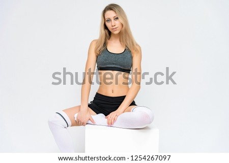 Concept portrait of a beautiful fitness girl blonde smiling on a white background advertisement.