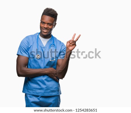 Young african american doctor man over isolated background wearing surgeon uniform smiling with happy face winking at the camera doing victory sign. Number two.