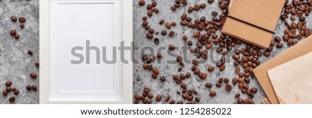 Mixture of different kinds of coffee beans, notebook and white mockup frame. Roasted coffee beans background. Panorama