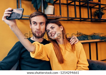 man and woman take pictures of themselves on the phone                    
