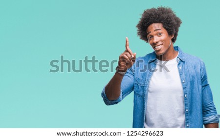 Afro american man over isolated background pointing finger up with successful idea. Exited and happy. Number one.