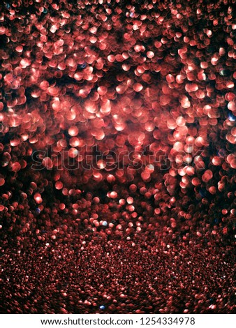 Bright glitter bokeh and sparkles on black holiday background. Living Coral color.
