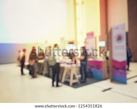 blurred image of people walking on a trade fair exhibition or expo where business people show innovation activity and present product in a big hall.