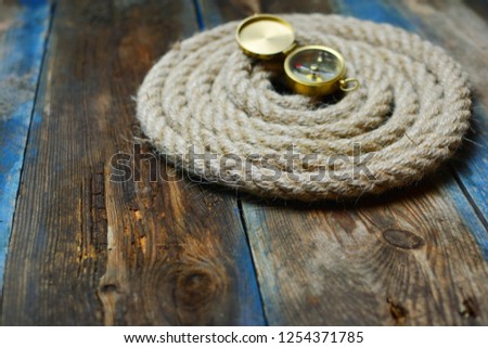 Nautical background. Old deck with rope and compass. 