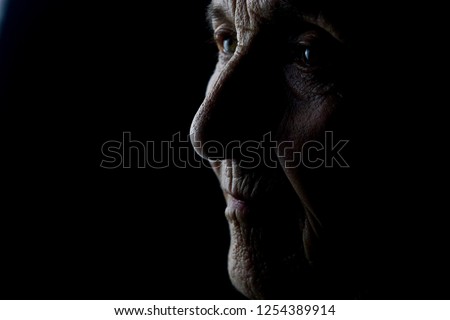 Old grandmother on a dark background