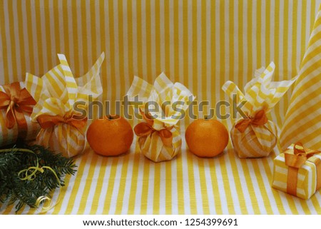 Happy new year concept. Tangerines, gifts, fir branches on an orange background.