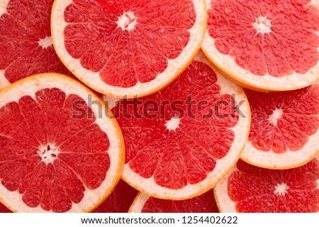 Close-up Grapefruit slices abstract background in Living Coral color of the Year 2019. Bright summer texture. Royalty-Free Stock Photo #1254402622