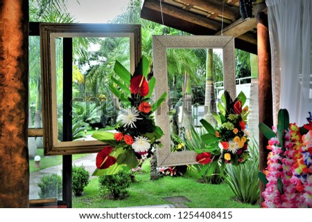 Picture frames decorated with tropical flowers hanging from the ceiling