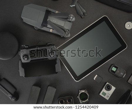 Work space photographer with laptop, digital camera, memory card, action camera, drone, remote controller, phone and camera accessory. Top view on black table background. Concept of mockup template.
