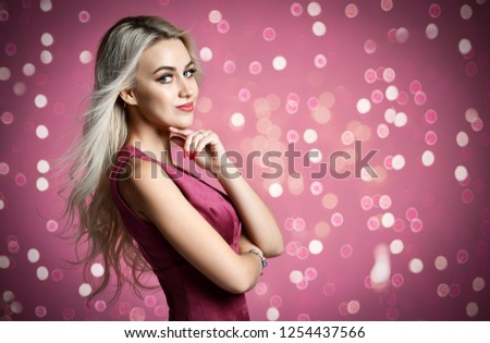 Blonde woman beautician cosmetologist posing on purple pink with christmas celebration lights  background