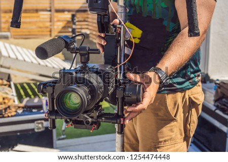 Steadicam operator prepare camera and 3-axis stabilizer-gimbal for a commercial shoot