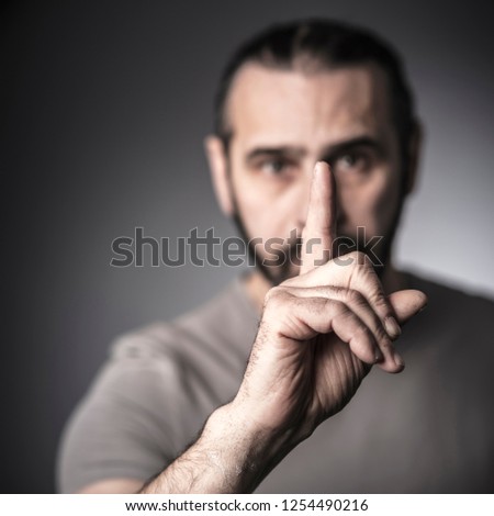 portrait of man gesture silence with hand, selective focus