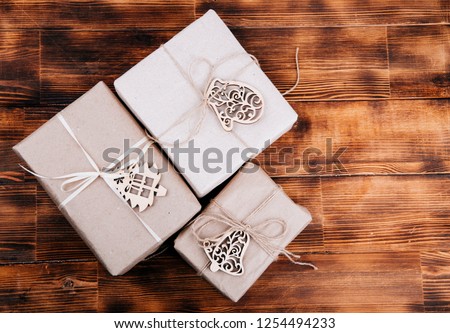 gift in Kraft paper, on a wooden background.