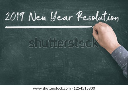 Close up of human hand writing 2019 New Year Resolution Check List on Blackboard