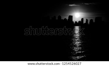 San Diego skyline in monochrome black and white with beautiful contours of down town cityscape with burning sun reflecting in sea water. 
More similar content is found in my portfolio. 