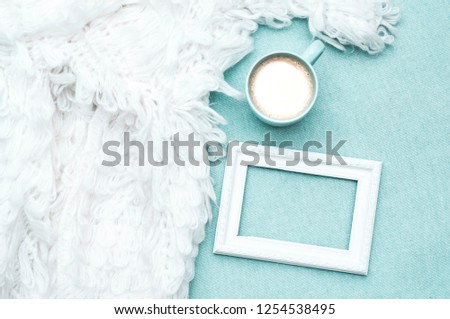 Coffee with milk, blanket of gently blue color, photo frame, white fluffy cape